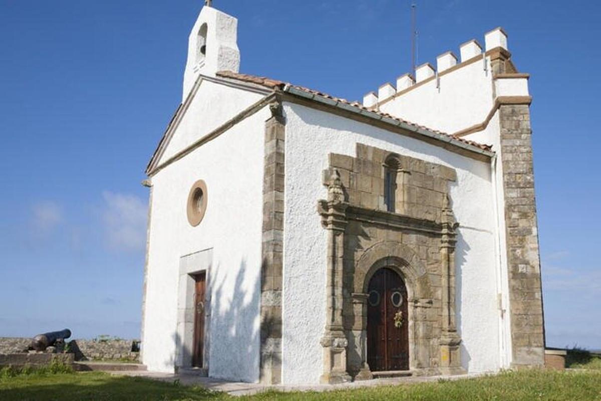 an old white church with a tower on a field