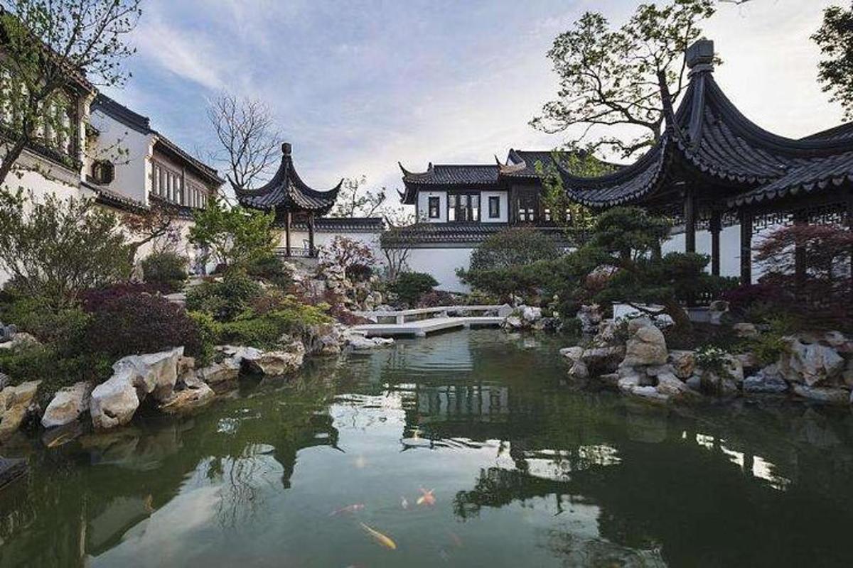 a garden with a pond in front of a building