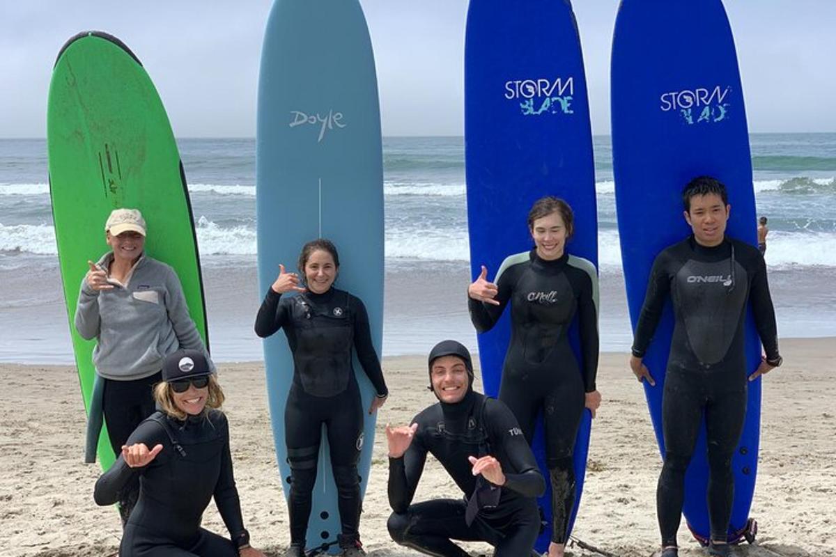 un grup de oameni care stăteau pe plajă cu plăci de surf