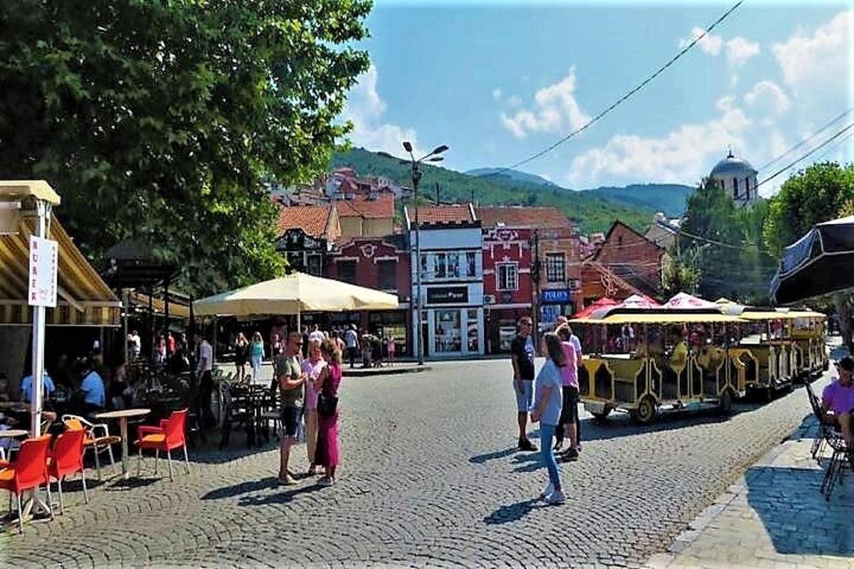 skupina lidí stojících na ulici s vozíkem