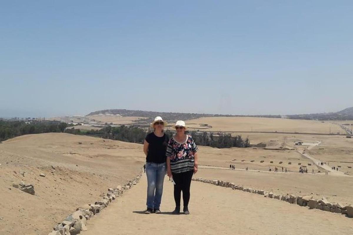 two women standing on the top of a hill