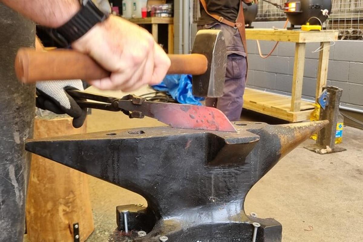 a man cutting a metal object on avil