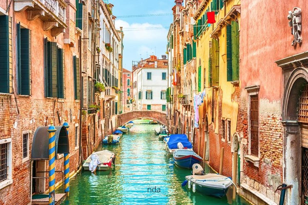 un gruppo di barche in un canale tra edifici