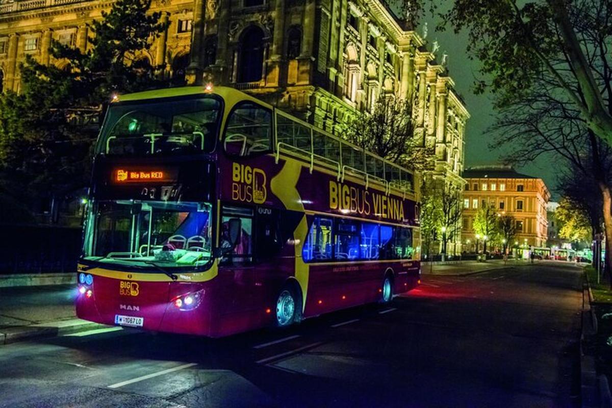 ein Doppeldeckerbus, der nachts eine Straße entlangfährt