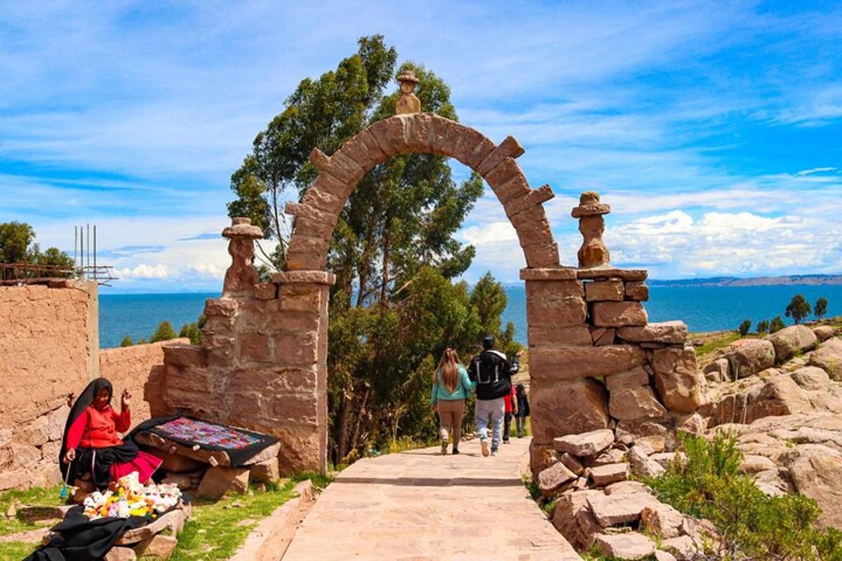 a stone archway with people walking down a sidewalk