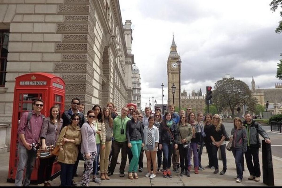 a group of people standing on a street with a telephone booth