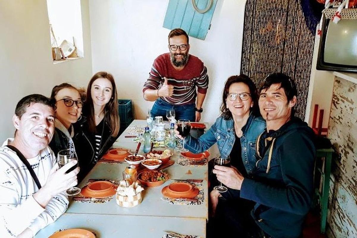 skupina lidí sedících kolem stolu s vinnými sklenicemi