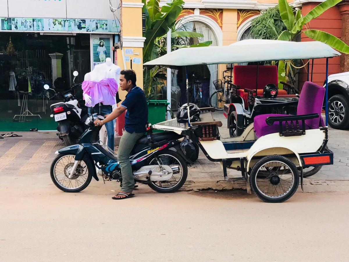 um homem em pé em uma motocicleta com um carrinho