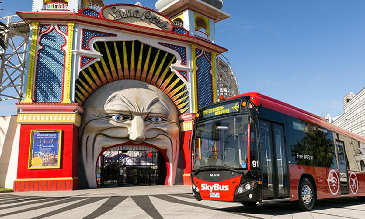 a bus parked in front of a building with a large face