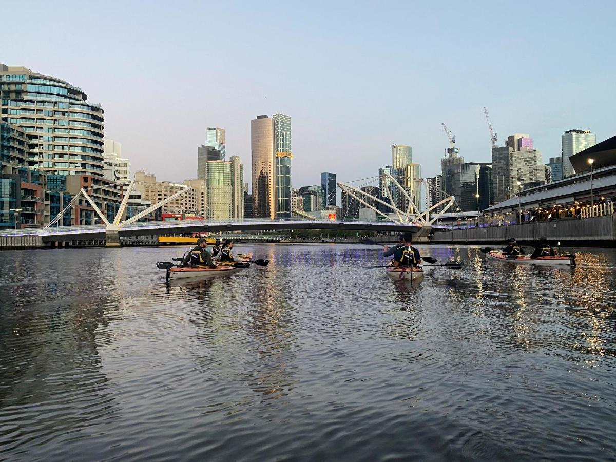 a group of people in canoes on a river in a city
