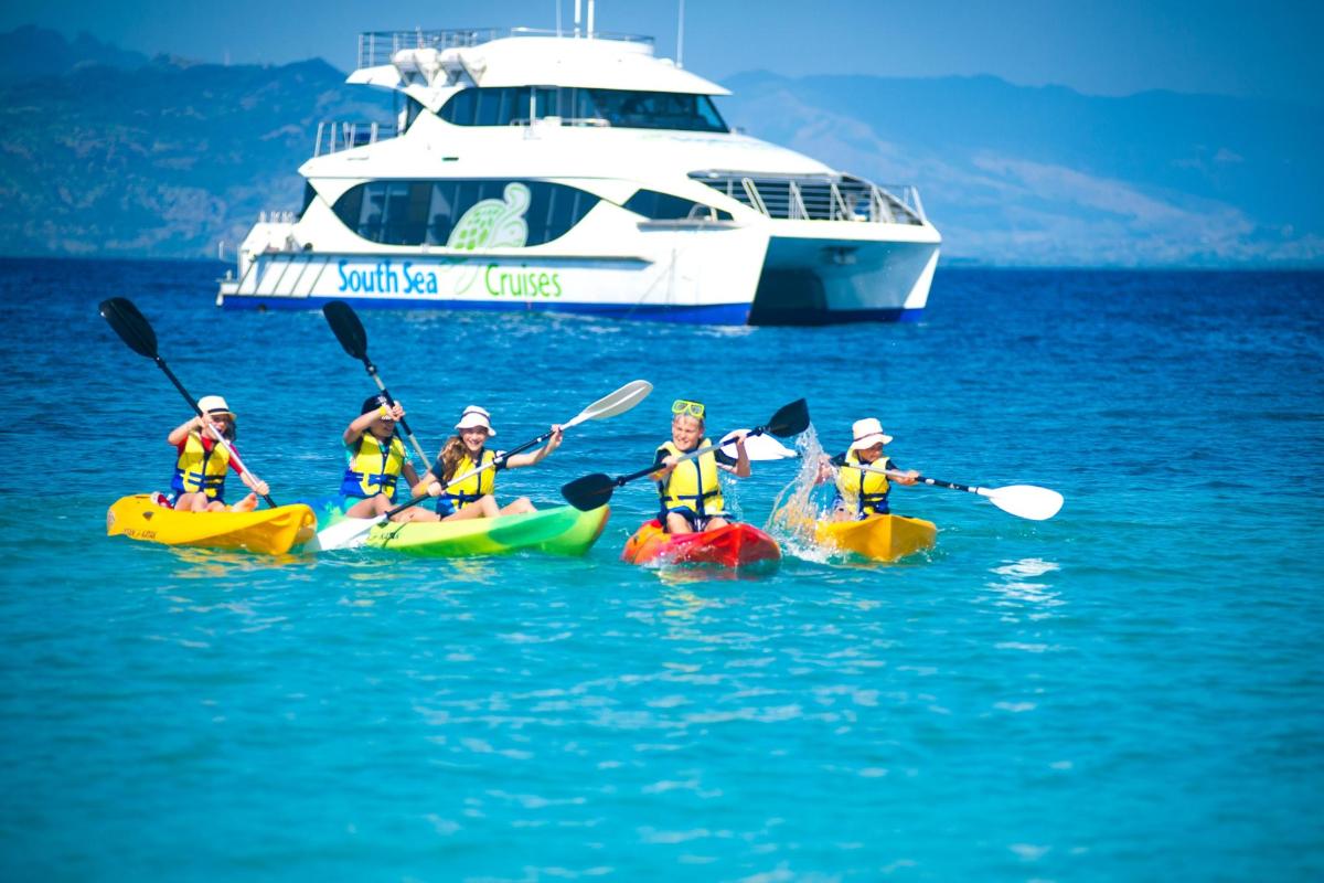 a group of people in kayaks in the water with a boat