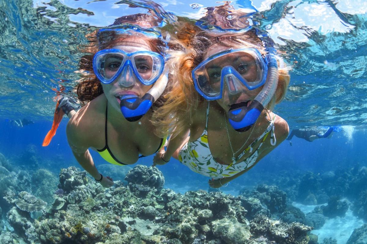 two women swimming in the water with goggles on