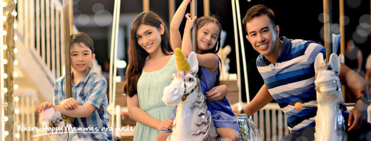 un uomo, una donna e due bambini su una giostra