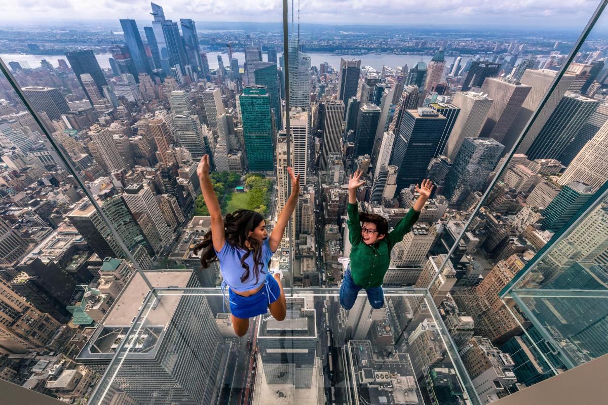 a couple jumping off the floor of the skyscraper