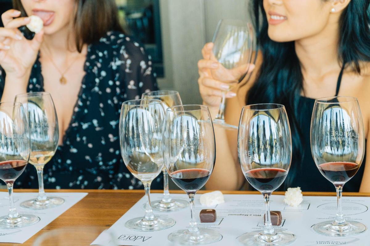 due donne sedute a un tavolo con bicchieri di vino