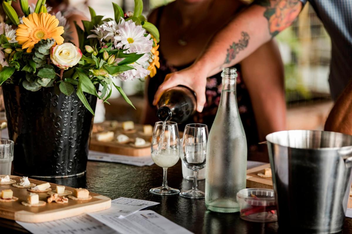 a person pouring wine into glasses on a table