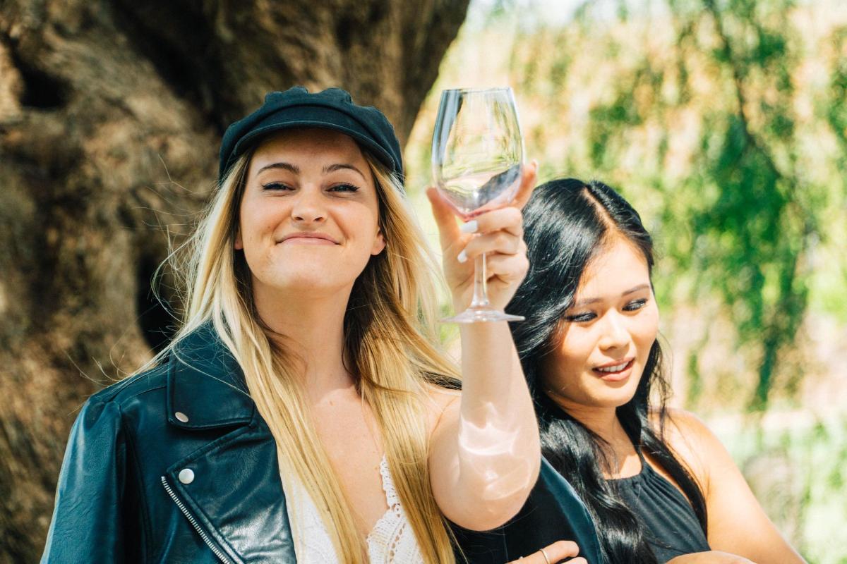 due donne che tengono in mano un bicchiere di vino