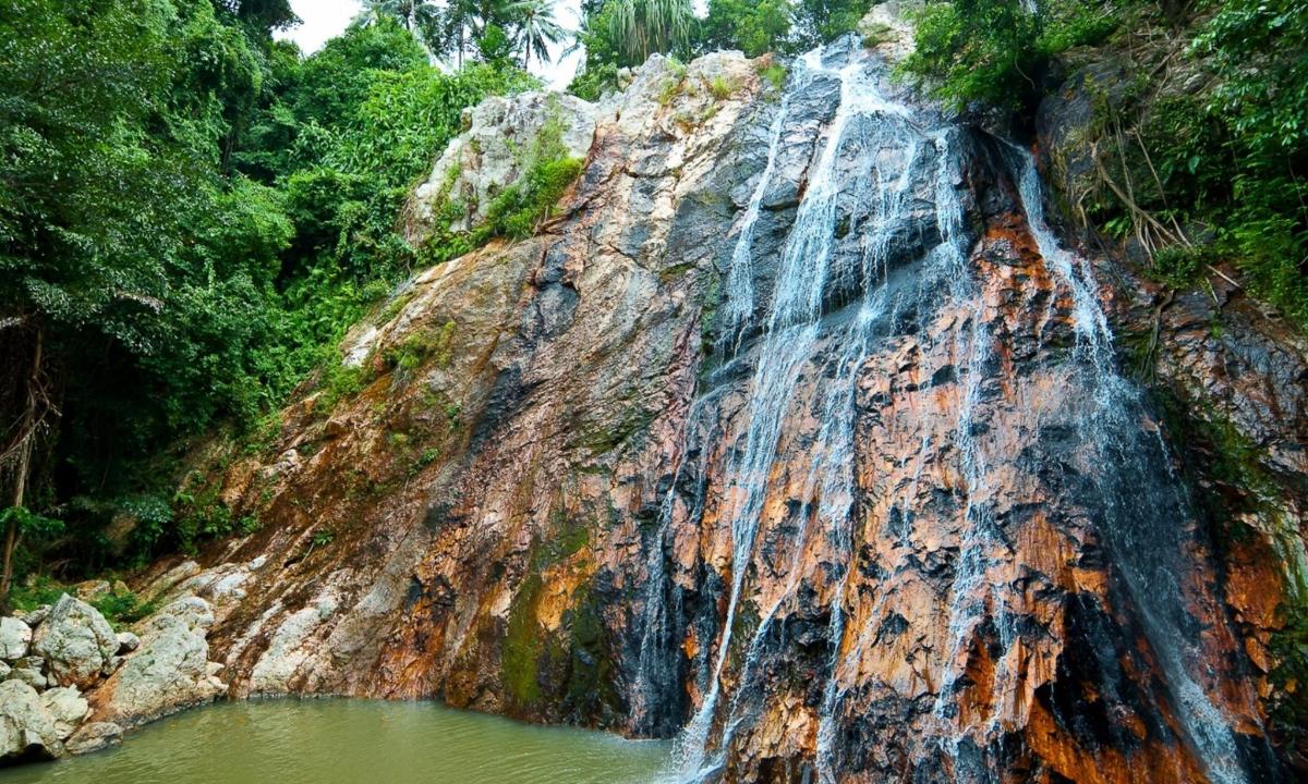 a waterfall in the middle of a pool of water