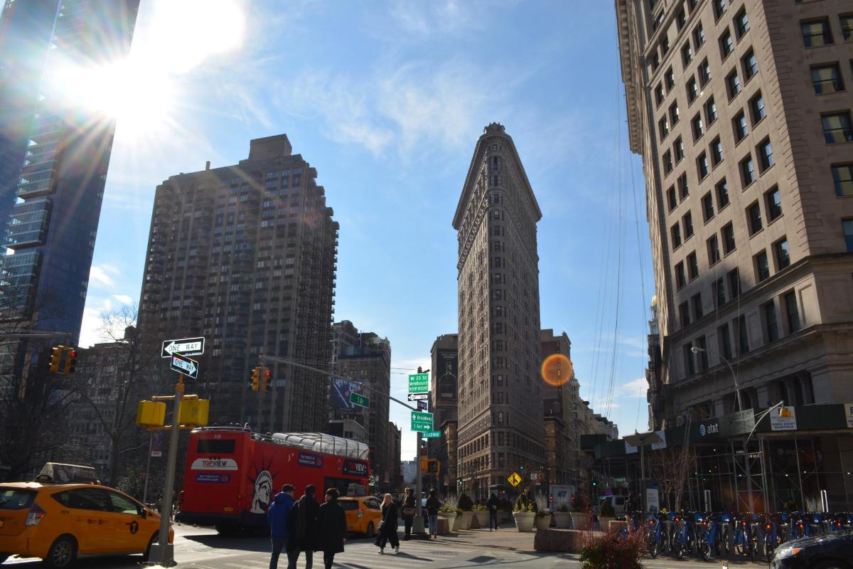 a busy city street with a red double decker bus