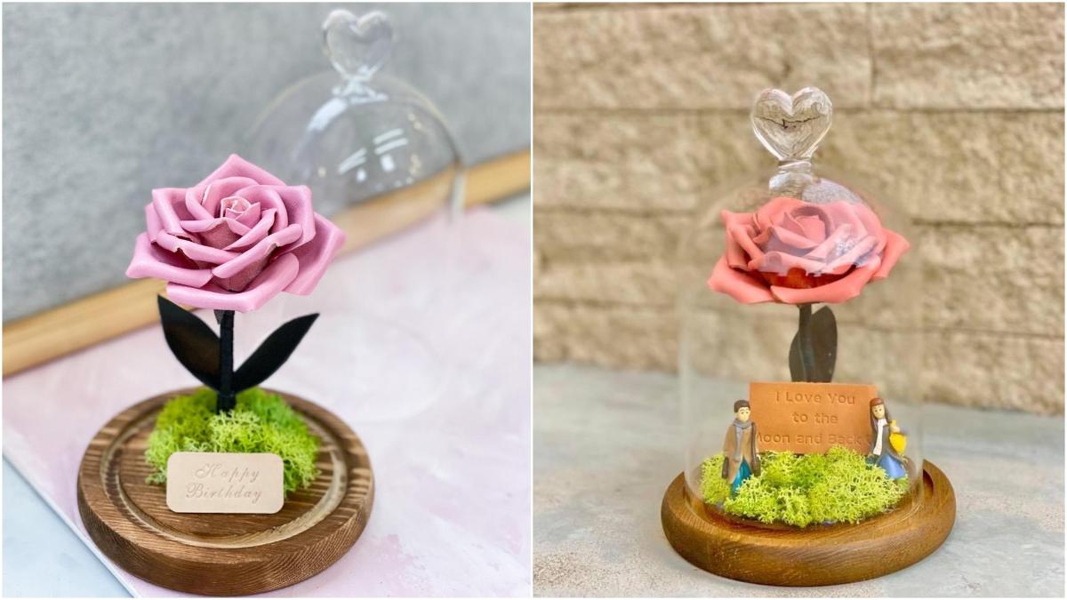 một bông hồng thu nhỏ trong một mái vòm kính có gắn thẻ trên đó