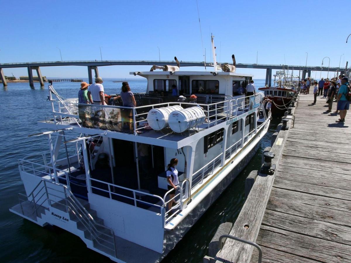 Un barco atracado en un muelle con gente en él.