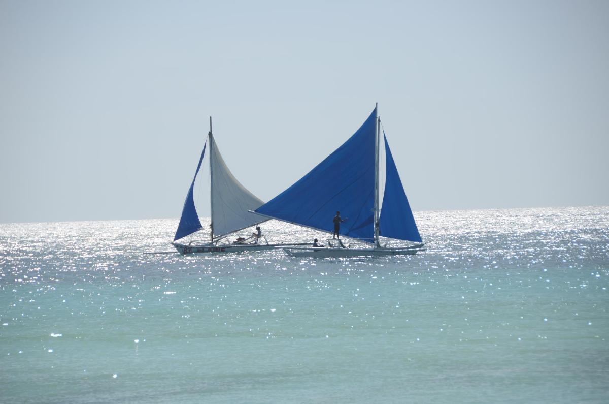 two sailboats are in the water on the ocean