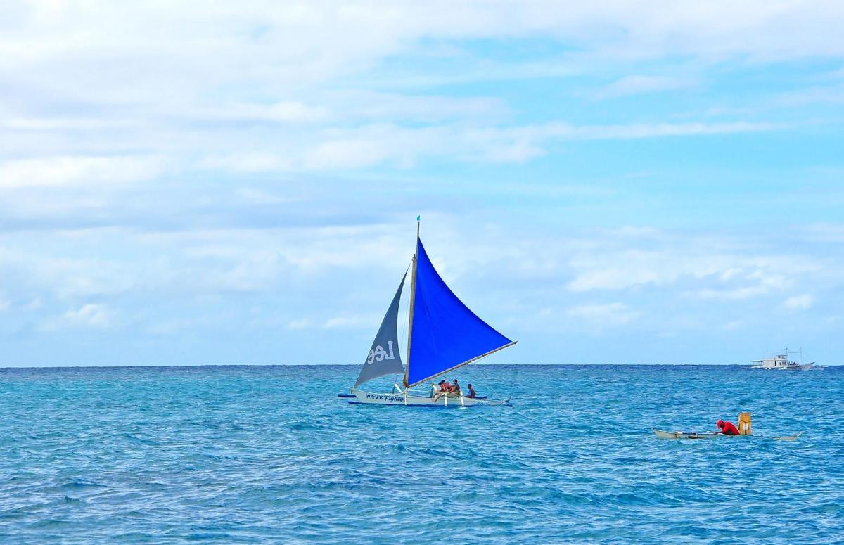 a group of people on a sail boat in the ocean