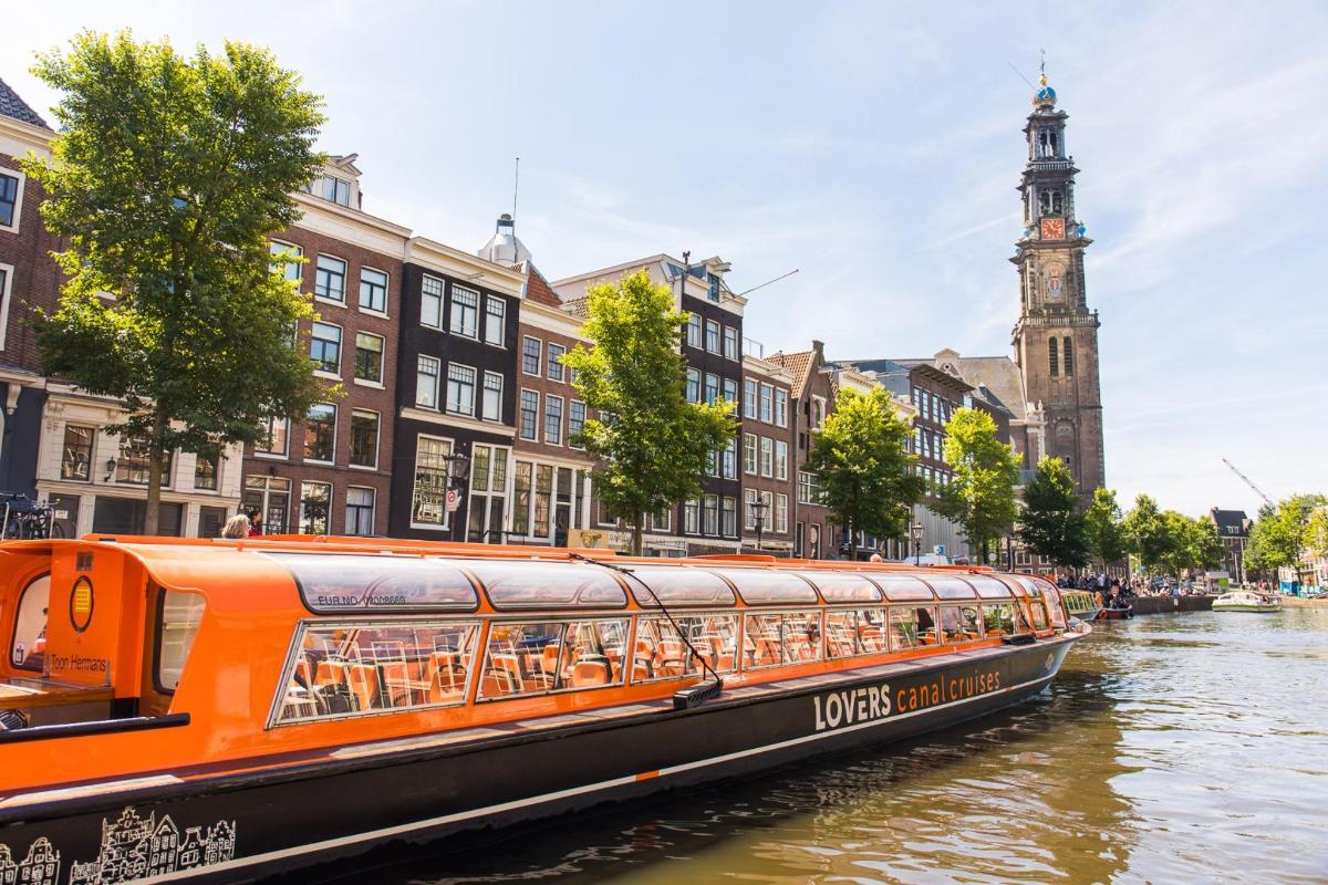 an orange boat on a river in a city