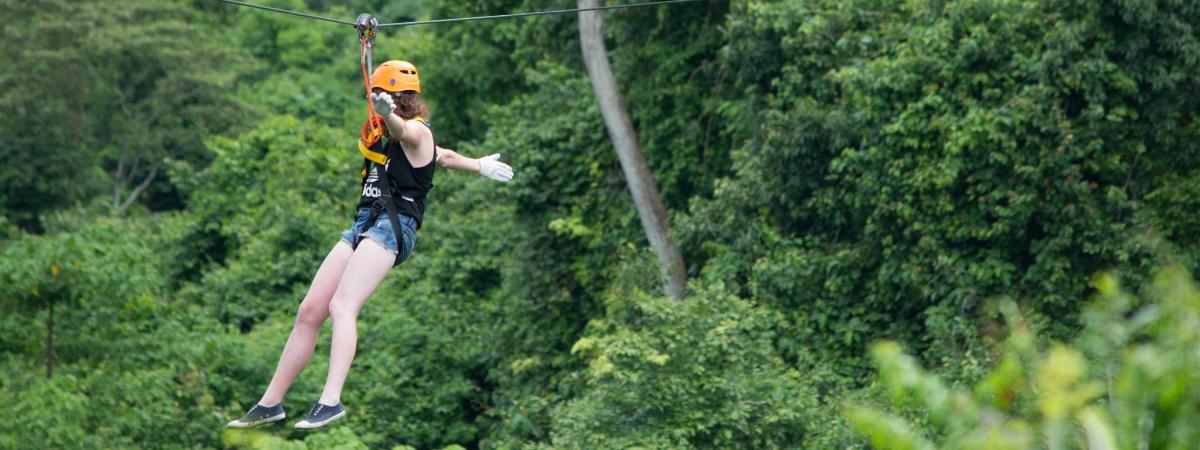 a woman is hanging on a zip line