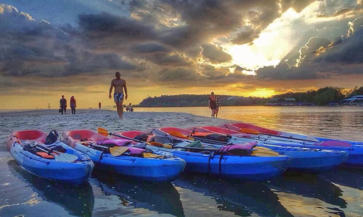 un gruppo di barche sedute sulla spiaggia al tramonto