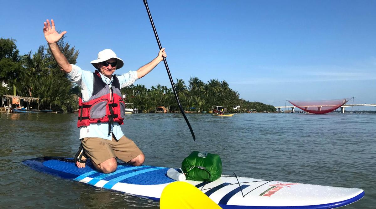 a man is sitting on a paddle board in the water