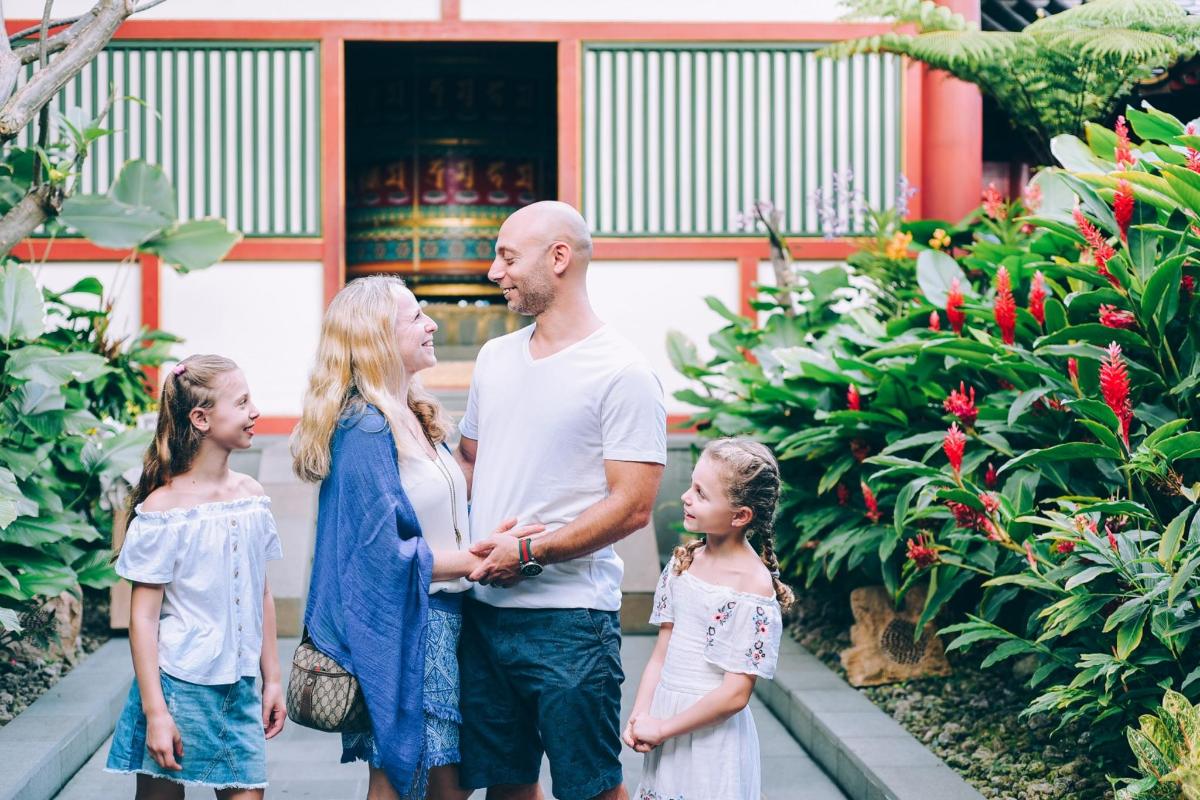 una famiglia in piedi davanti a un giardino