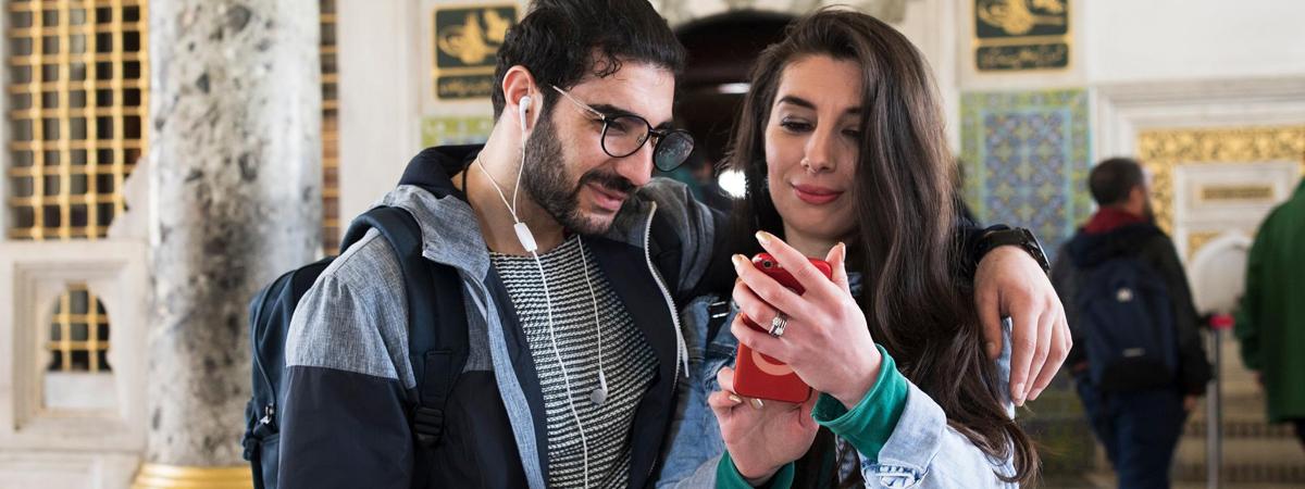 muž a žena se dívají na mobilní telefon