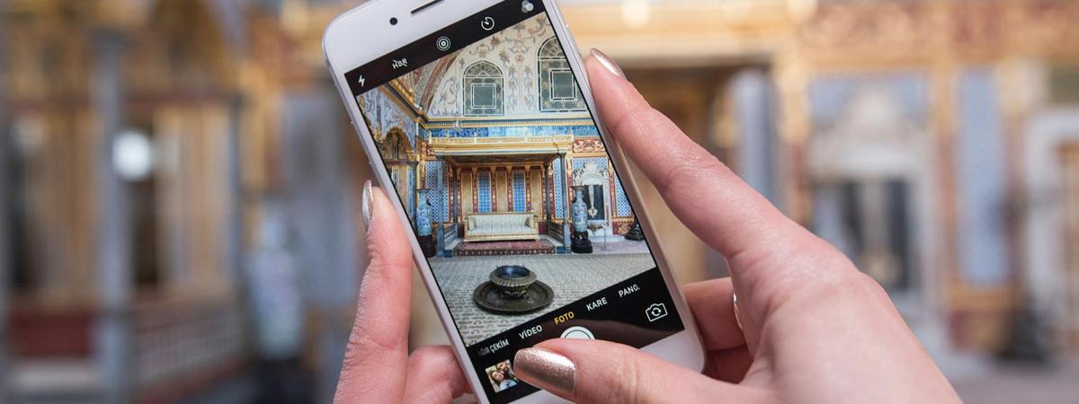 osoba fotící budovu mobilním telefonem