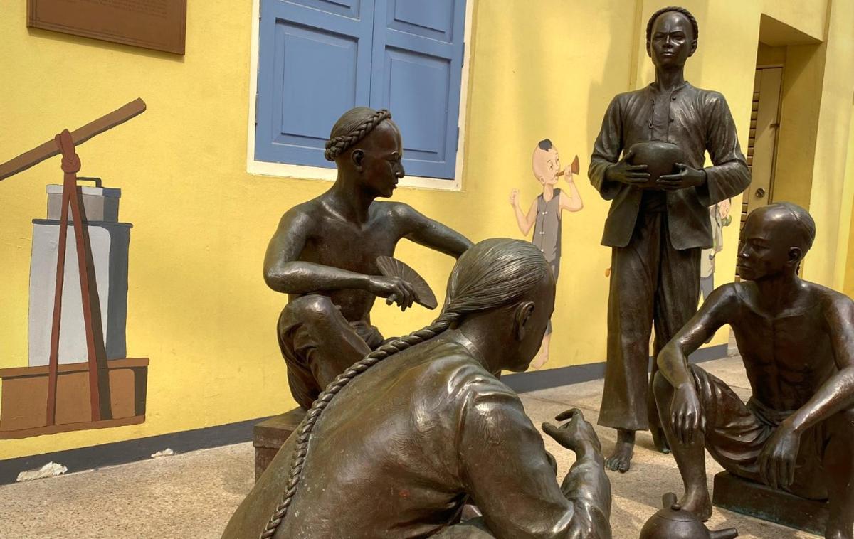 en statue af tre personer, der sidder ved siden af hinanden