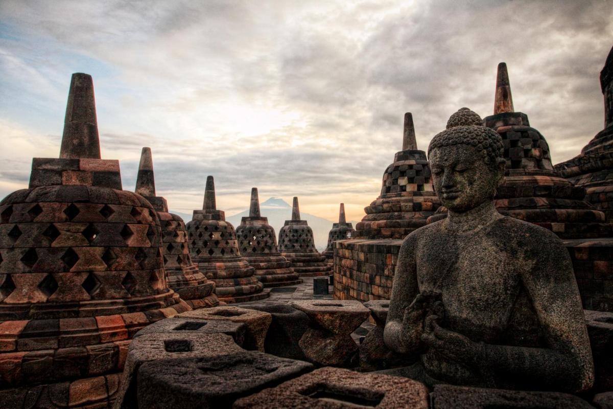 a statue in front of a group of temples