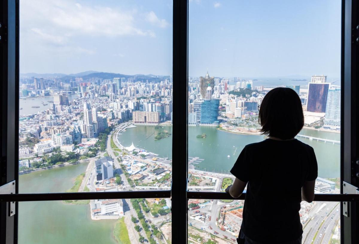 a woman looking out of a window at a city