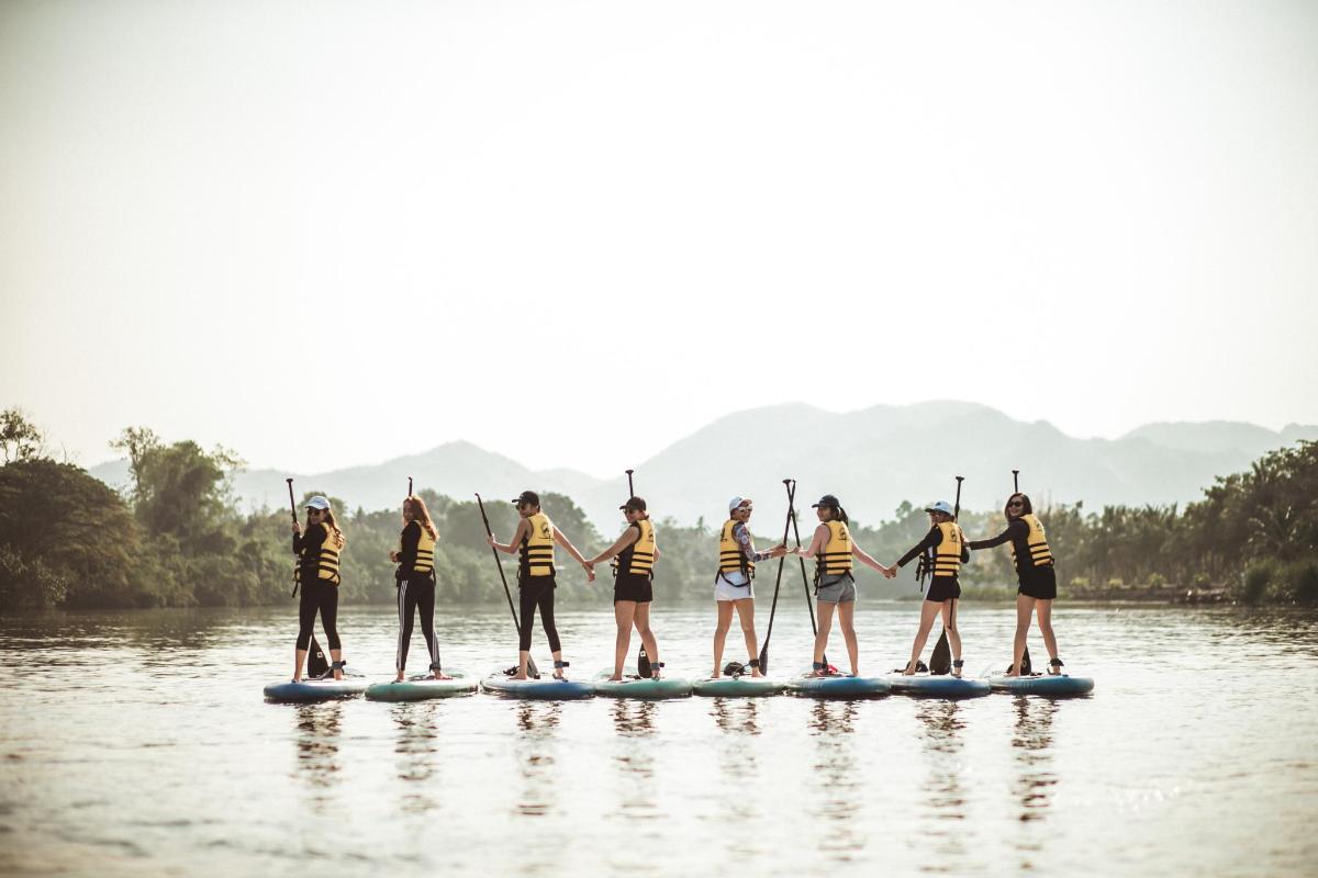 a group of people on a paddle board on the water