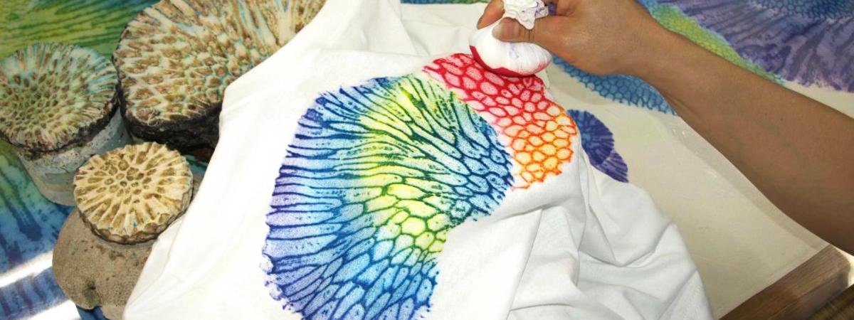 a person holding a peacock feather on top of a cake
