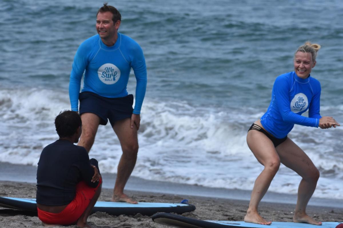 eine Gruppe von Menschen steht auf Surfbrettern am Strand