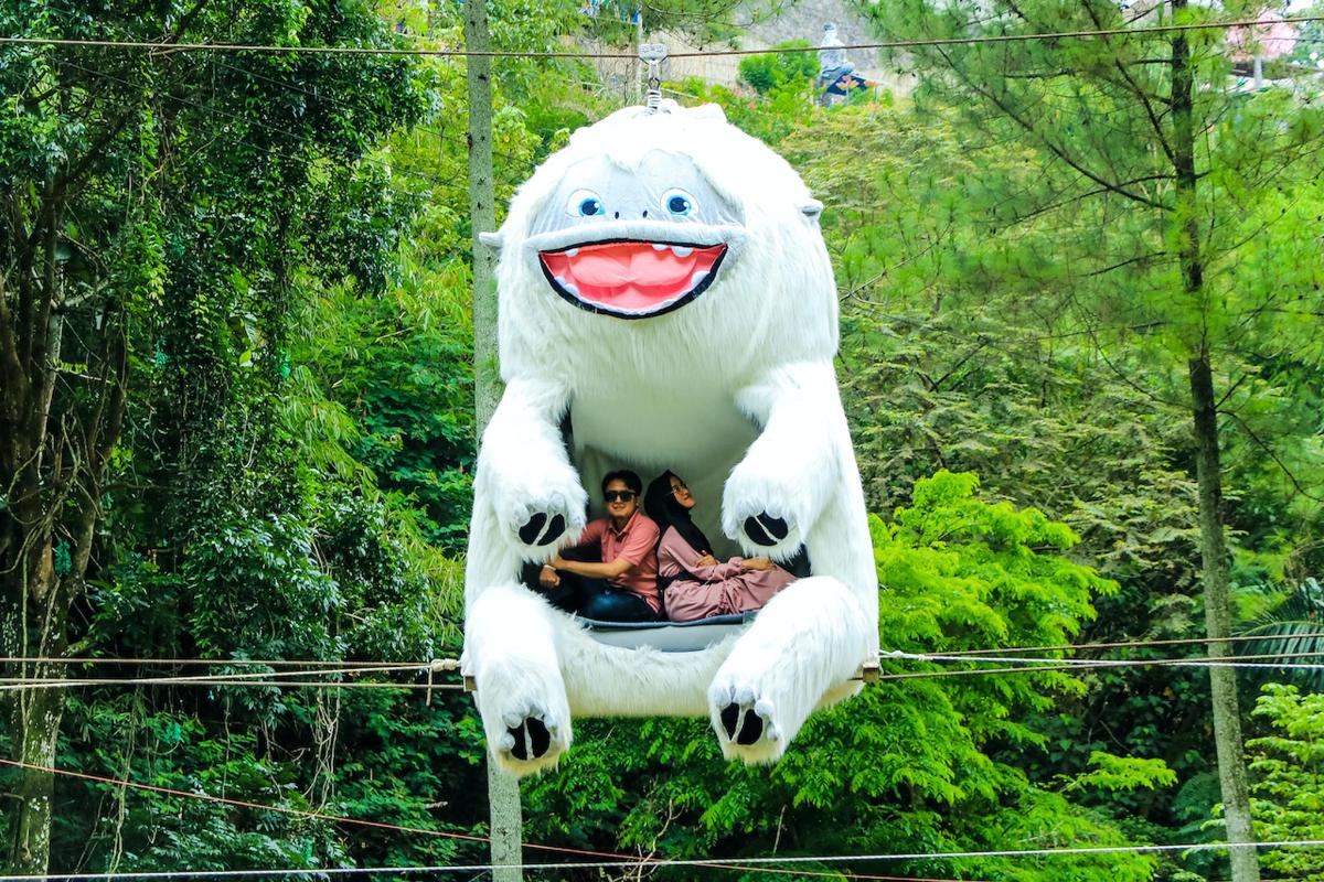 Un gran animal inflable con dos personas sentadas en él.