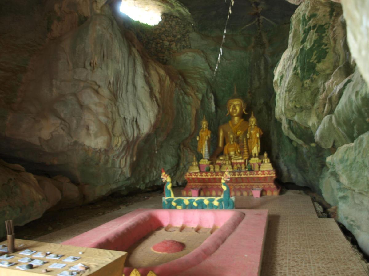 Un templo en una cueva con una estatua al fondo.