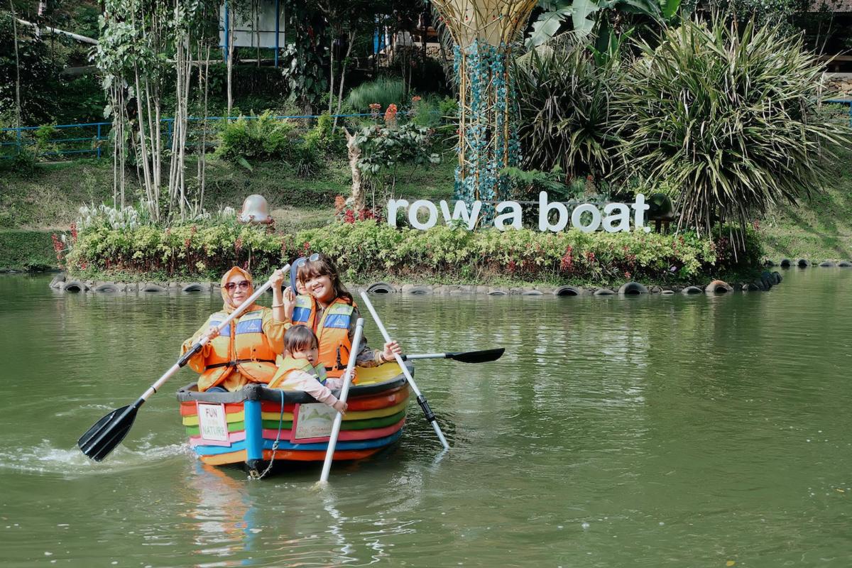 een gezin dat in een bootje op een rivier peddelt