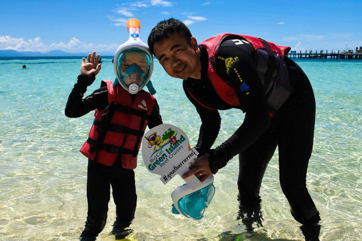 un uomo e un bambino in acqua con un casco da sub