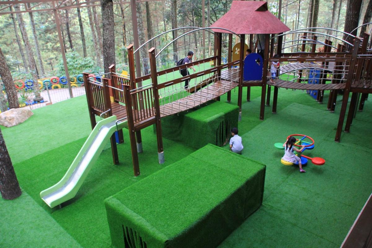 a playground with a slide and children playing in it