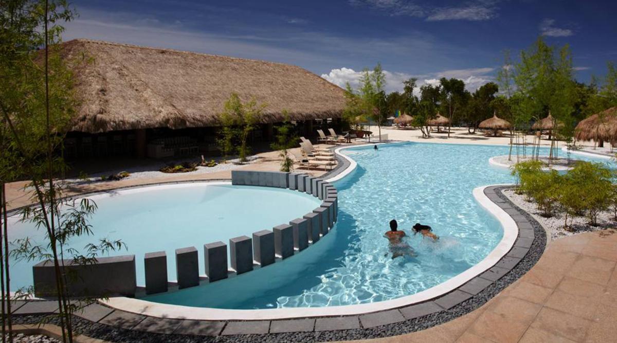 dues persones en una piscina d'un complex turístic