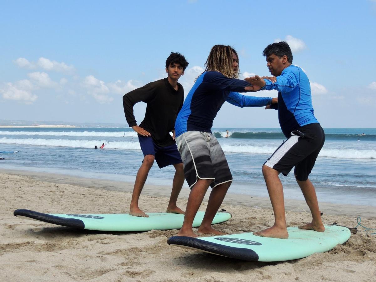 a group of people standing on surfboards on the beach
