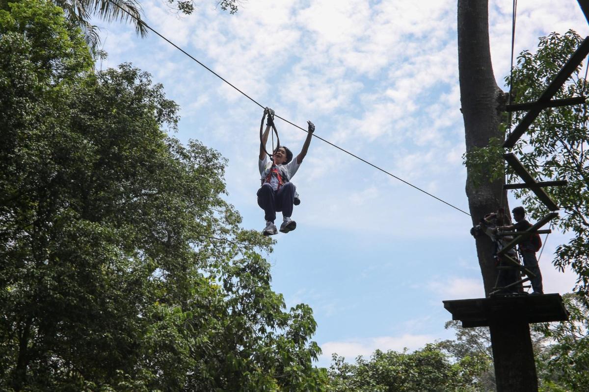 a woman is hanging on a zip line