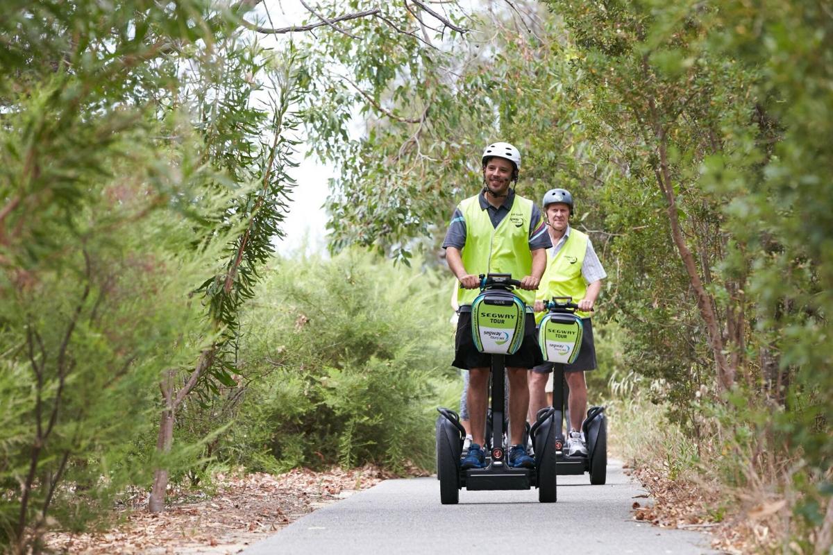 Tveir menn ríða á Segway á vegi