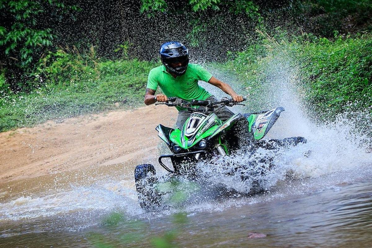 un uomo che guida un quad attraverso l'acqua